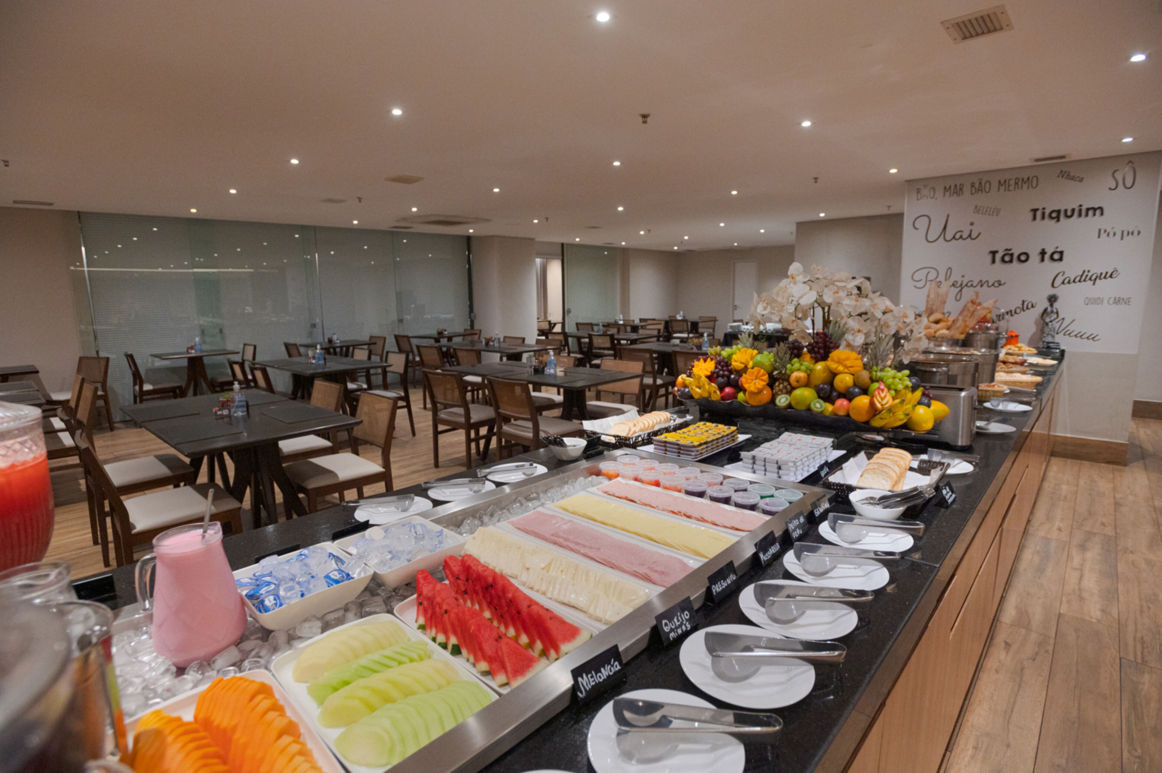 A buffet with various food options and a wall with text in a foreign language.