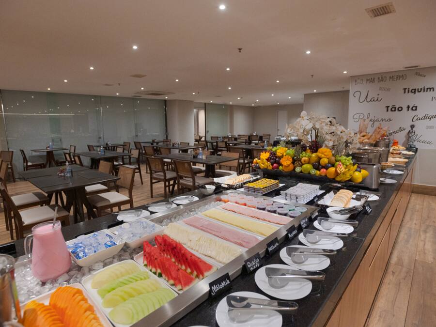 A buffet with various food options and a wall with text in a foreign language.