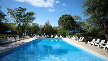 Una piscina techada, una piscina al aire libre de temporada, sombrillas