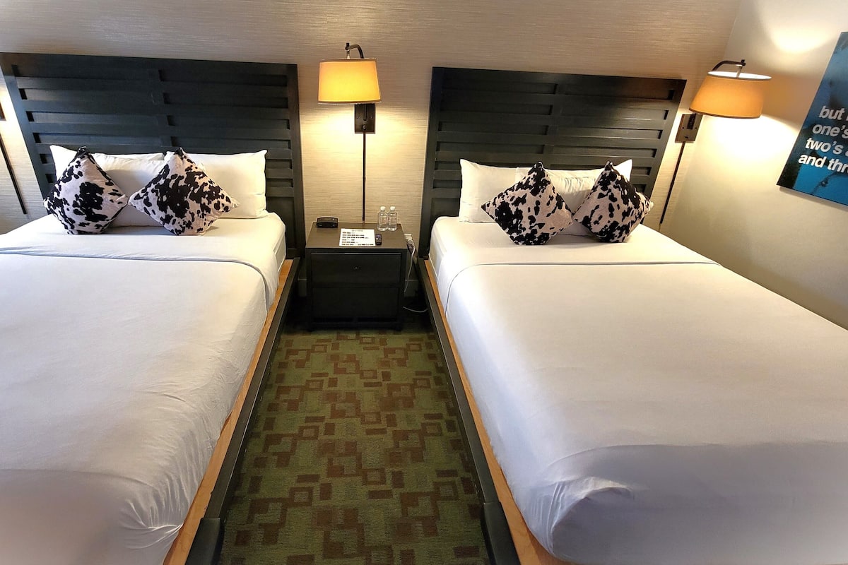 Habitación Deluxe, 2 camas Queen size | Tabla de planchar con plancha, wifi gratis y ropa de cama