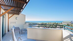 Ein Balkon mit Meerblick, einem Tisch und zwei Stühlen.