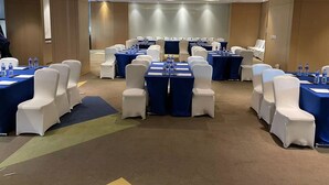 Ein Konferenzraum mit Reihen von Tischen und Stühlen, ausgestattet mit Wasserflaschen und Dokumenten.