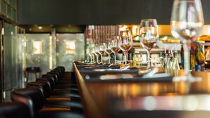 A bar with a long counter and several wine glasses lined up. - NYX Tel Aviv (Tel Aviv)