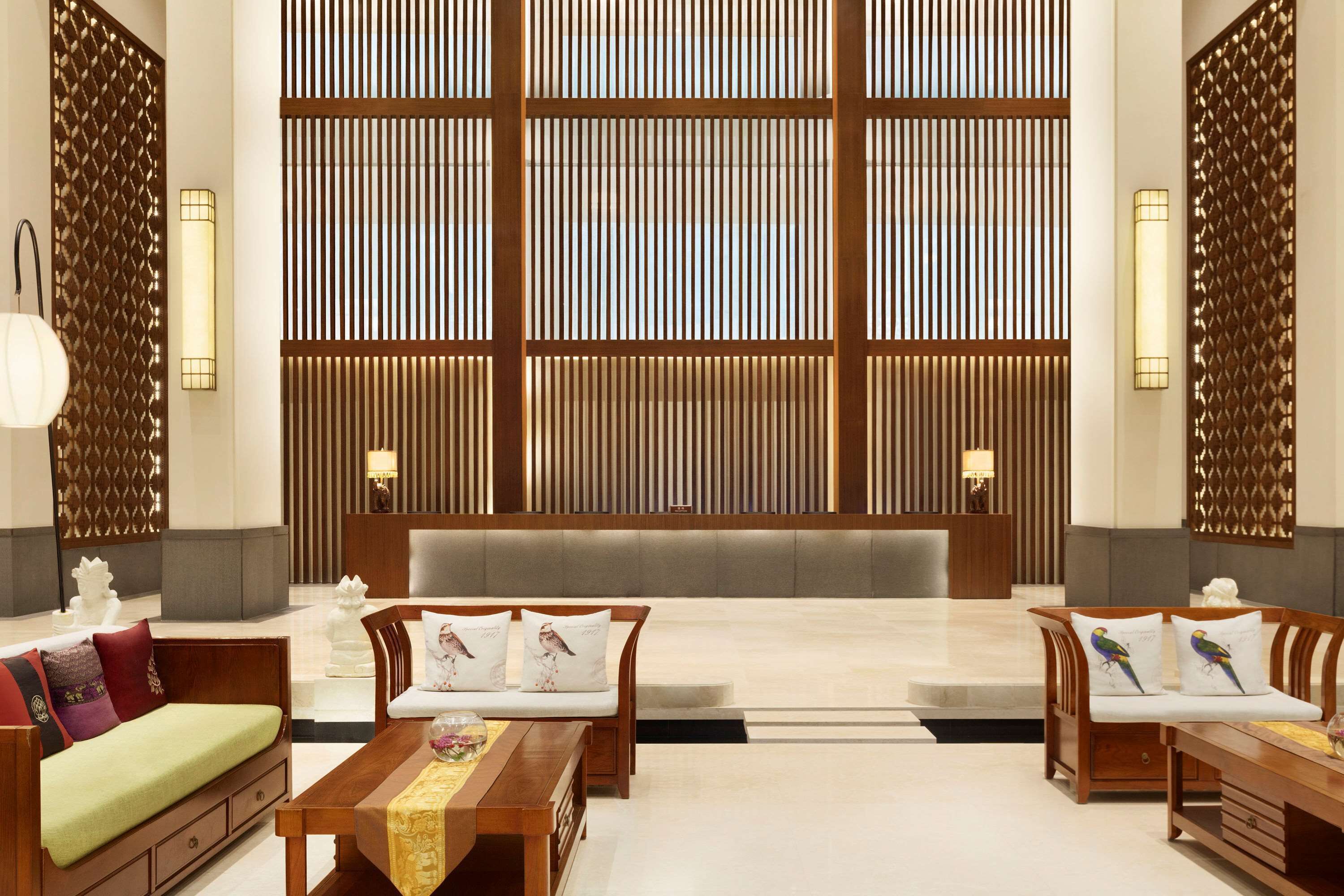 A spacious lobby with a central seating area, wooden paneling, and modern lighting fixtures.