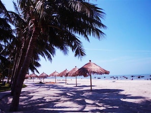 Playa privada, arena blanca, sillas reclinables de playa, sombrillas