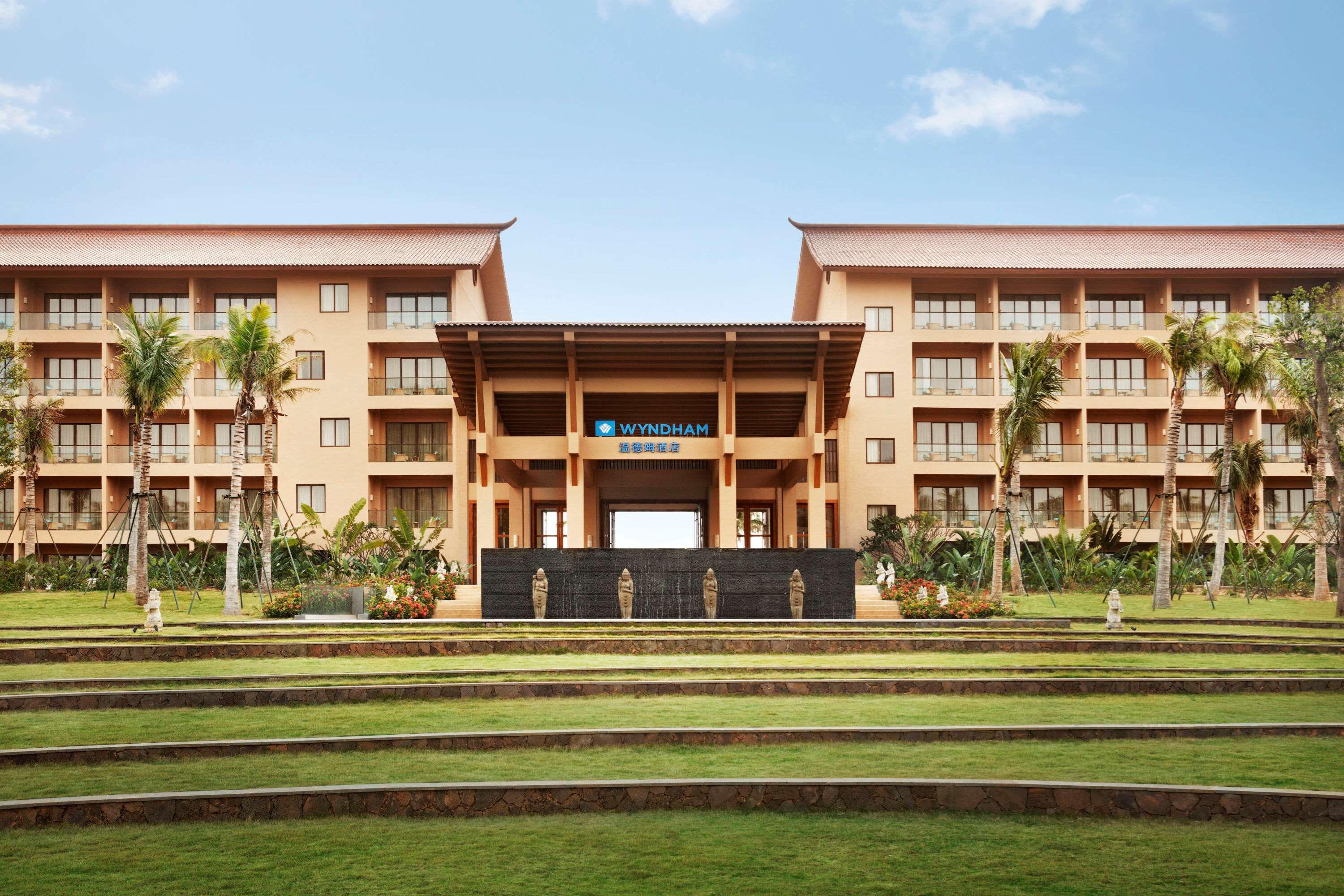 A hotel with a symmetrical facade, multiple balconies, and a central entrance.