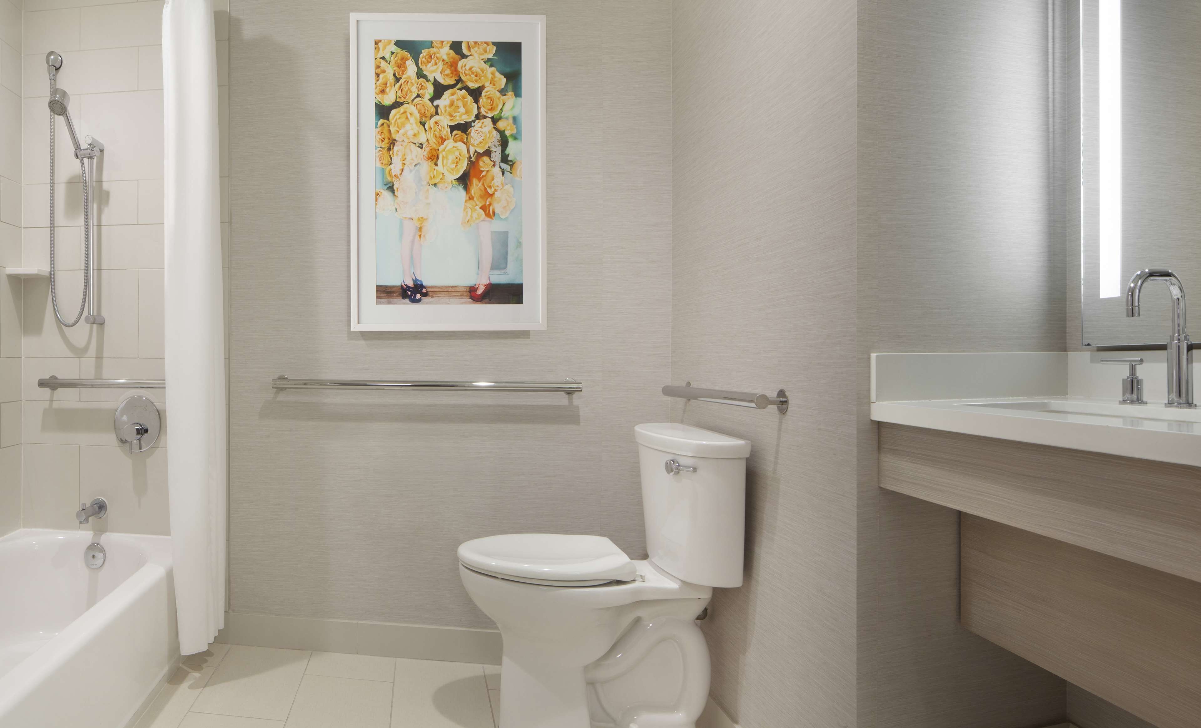 A modern bathroom with a toilet, shower, and sink.