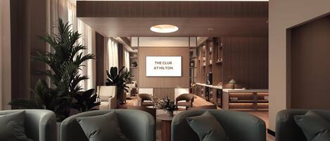 A modern hotel lounge with green sofas, a marble coffee table, and a large screen displaying 'THE CLUB AT HILTON'.