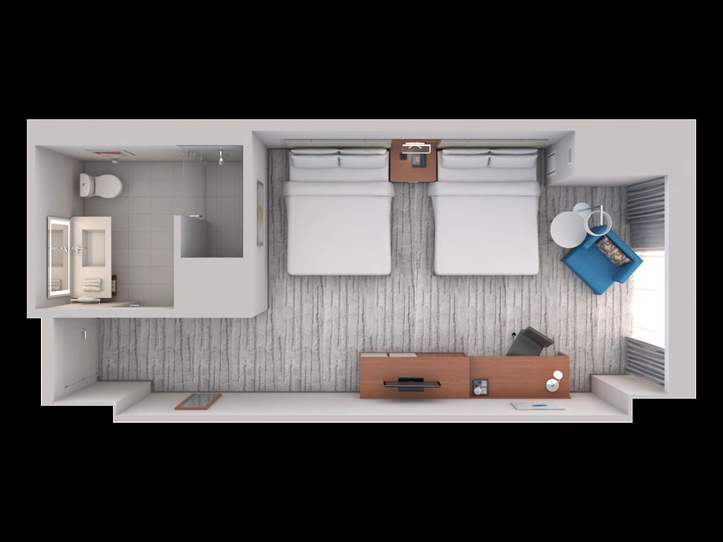 Una habitación de hotel moderna con ducha, inodoro y una cama con cortinas. Incluye un escritorio pequeño con una silla y una mesita de noche con una lámpara.