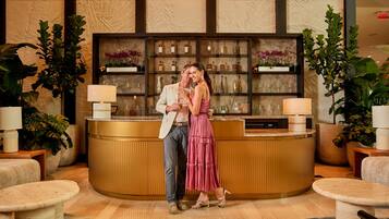 Guests can relax in the lobby's inviting atmosphere, surrounded by comfortable seating and lush greenery.