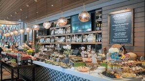 A buffet setup with various food items and a bar area with bottles and glasses.