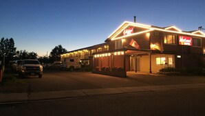 Motel Westwood de dos pisos, con entrada visible y zona de estacionamiento con vehículos.