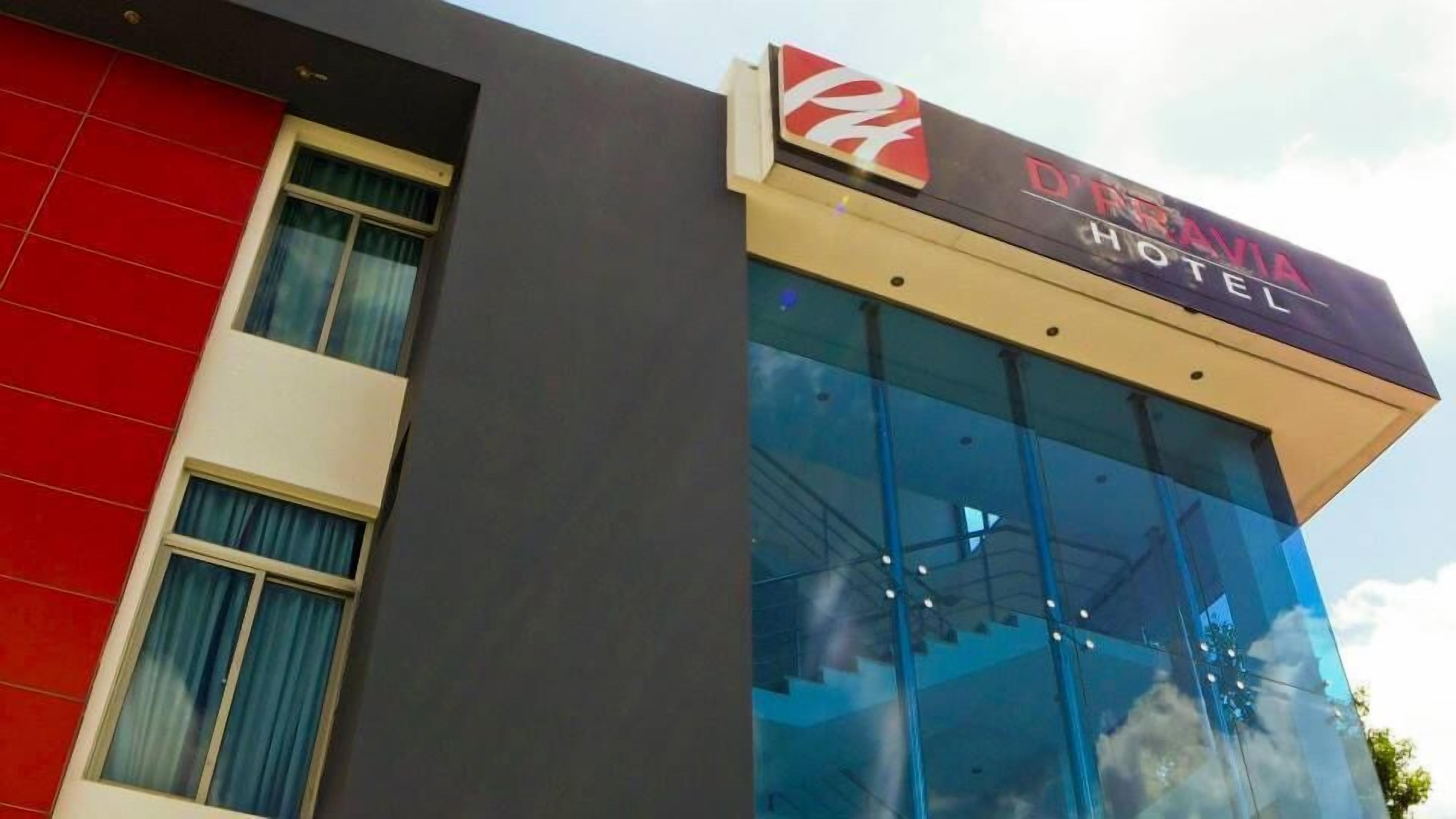 A hotel building with a modern glass facade and a red and grey exterior.
