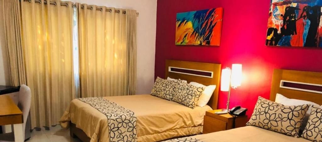 Habitación de hotel con dos camas, un escritorio y una silla.