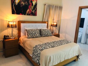 Relax in a stylish room with a large bed, two nightstands, and a beautiful abstract painting.
