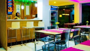 A restaurant with a counter, bar stools, and tables with chairs. - Dpravia Hotel SRL (Bani)