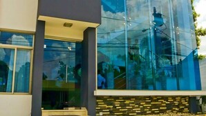 A modern building with large glass windows and a stone base. - Dpravia Hotel SRL (Bani)