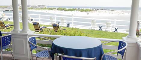 A covered outdoor seating area with a view of the beach.