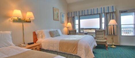 A hotel room with two beds, a chair, a balcony with curtains, and a view of the sea.