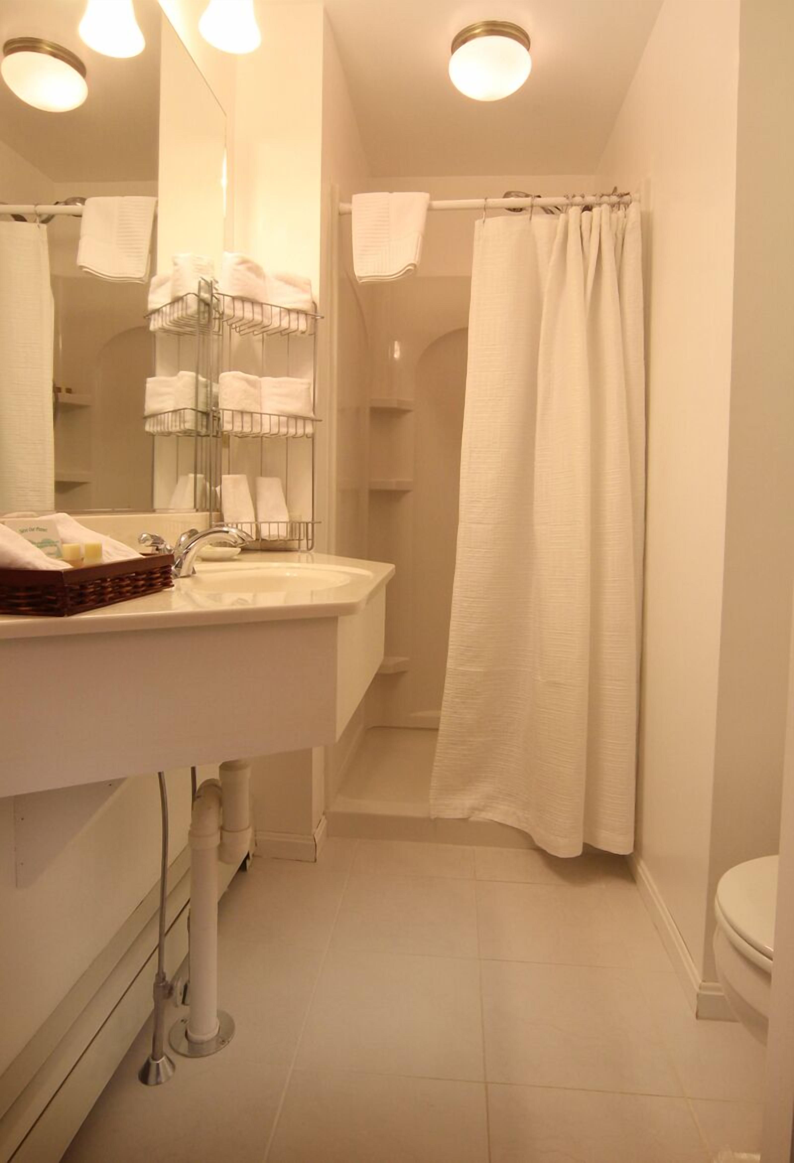 A bathroom with a white sink, mirror, and shower curtain.