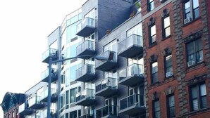 Un edificio de varios pisos con arquitectura moderna, con balcones y ventanas amplias.