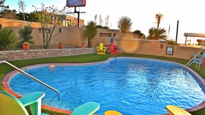 Una piscina con sillas coloridas y un cartel de The Maverick Inn al fondo.