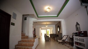 A spacious living area with a staircase, a sofa set, and a white cabinet. - Nicte Ha Campeche (Campeche)