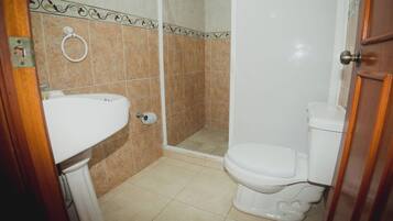 A bathroom with a toilet, sink, and shower.