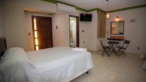 A hotel room with a bed, a desk with chairs, a TV, and a mirror. - Nicte Ha Campeche (Campeche)