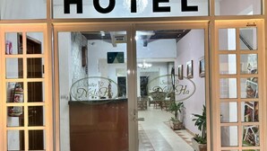 A hotel entrance with a reception desk, a sign indicating 'VISA' for payment, and a sign above the door reading 'HOTEL'. - Nicte Ha Campeche (Campeche)