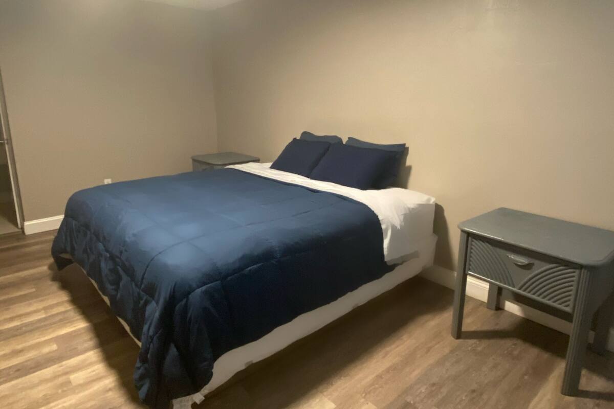 A bedroom with a bed, bedside tables, and a ceiling light.