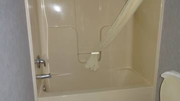 A bathroom with a bathtub, toilet, and shower curtain.