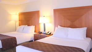 A hotel room with two beds, each with white linens and brown headboards. There are bedside tables with lamps and a phone. - Inn at San Luis Obispo (San Luis Obispo)