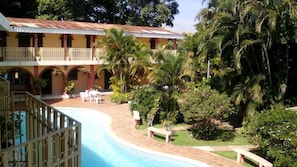 A hotel with a pool, outdoor seating, and lush greenery. - Hotel El Parador (Ahuachapan)