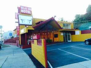 A motel with a yellow facade, a red awning, and a sign that reads "Relax Inn Motel". - Relax Inn Motel (Los Angeles)