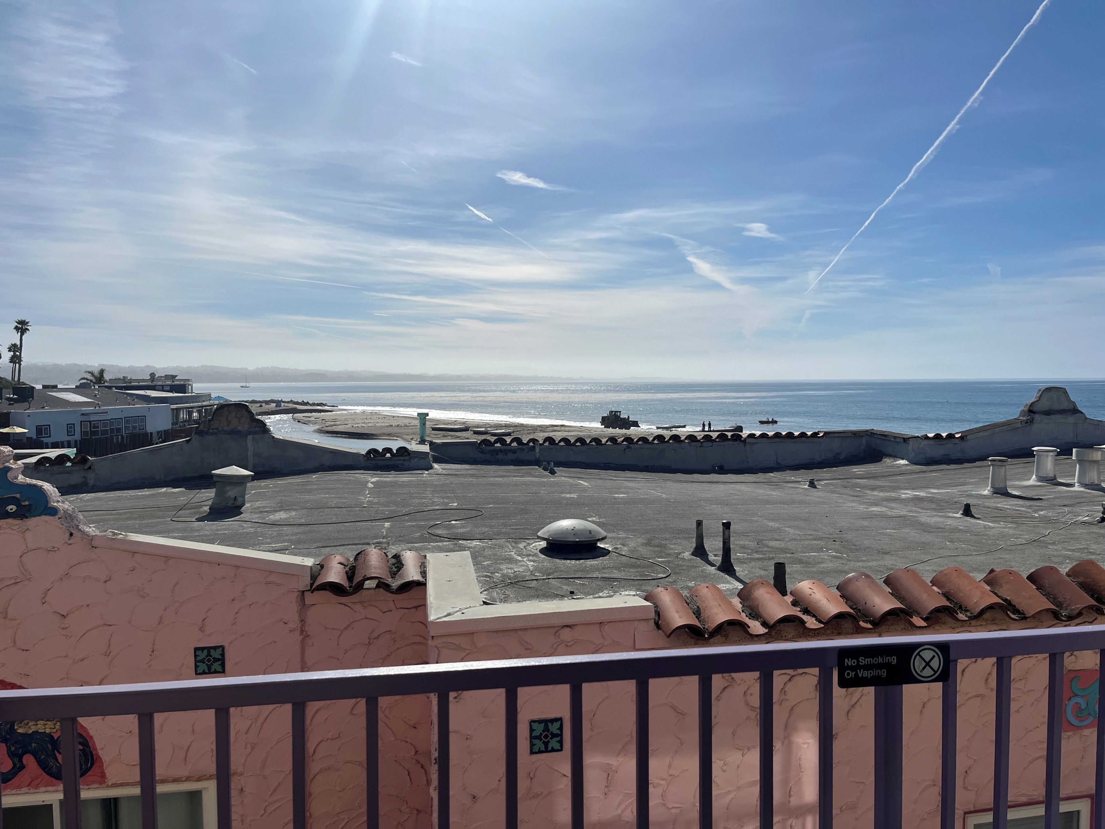 Vista costera con playa, muelle y cielo despejado.