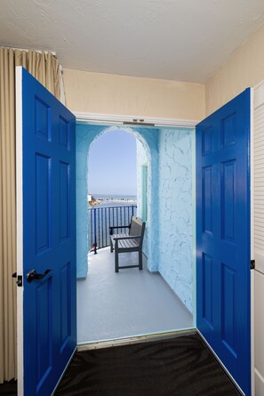 A hallway with blue doors leading to a balcony with a view of the beach. - Capitola Venetian Vacation Rentals (Capitola)