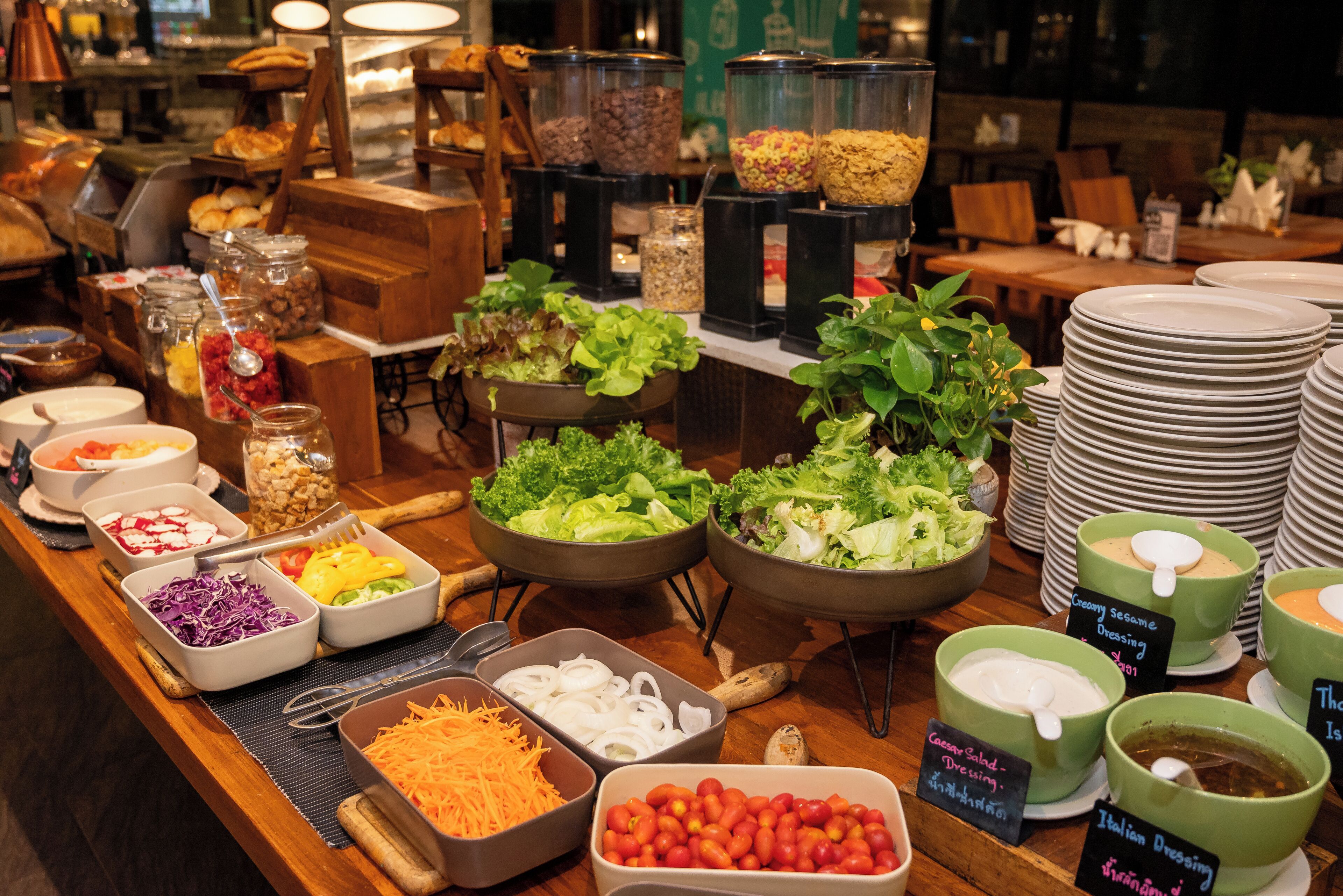 A buffet with various food options including salads, cheeses, and dressings.