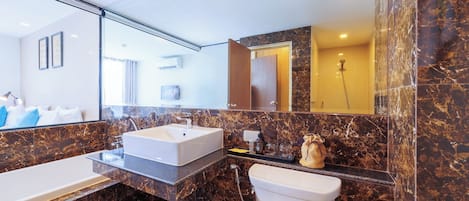 Un baño moderno con un espejo grande, dos lavamanos, un inodoro y una ducha.