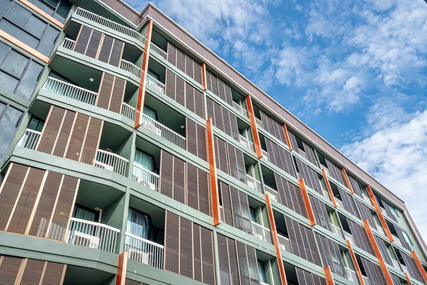 A multi-story hotel with balconies, a clear sky, and a modern architectural design.