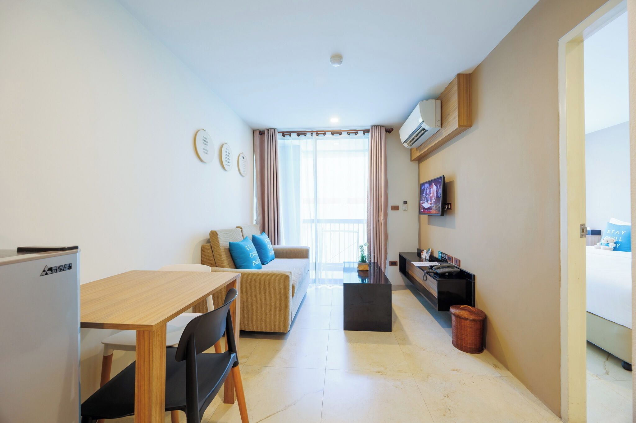A compact living space with a kitchenette, a dining area, and a seating area with a sofa and chairs.