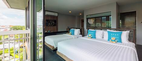 A hotel room with two beds, a balcony, and a city view.