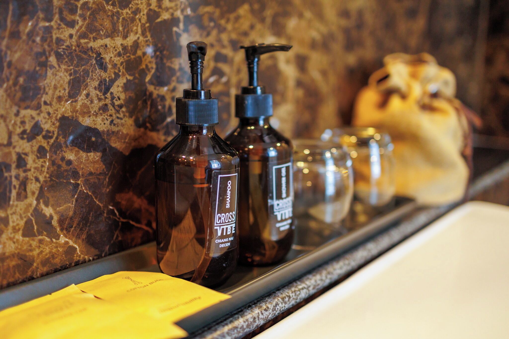 A bathroom shelf with various toiletries including bottles of shampoo and conditioner.