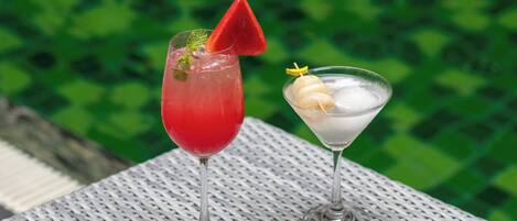 Two drinks on a table with a green background.