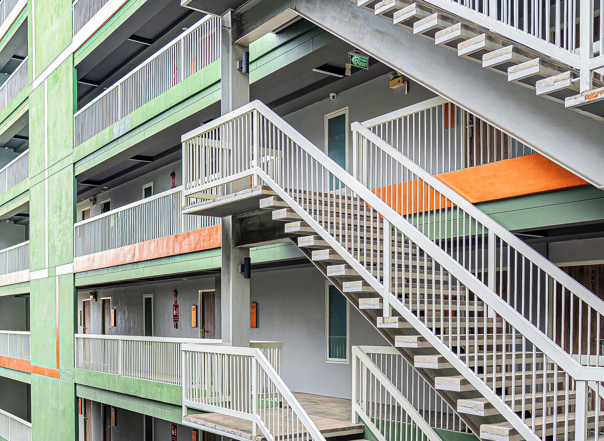 Un immeuble à plusieurs étages doté d’escaliers et de balcons extérieurs.
