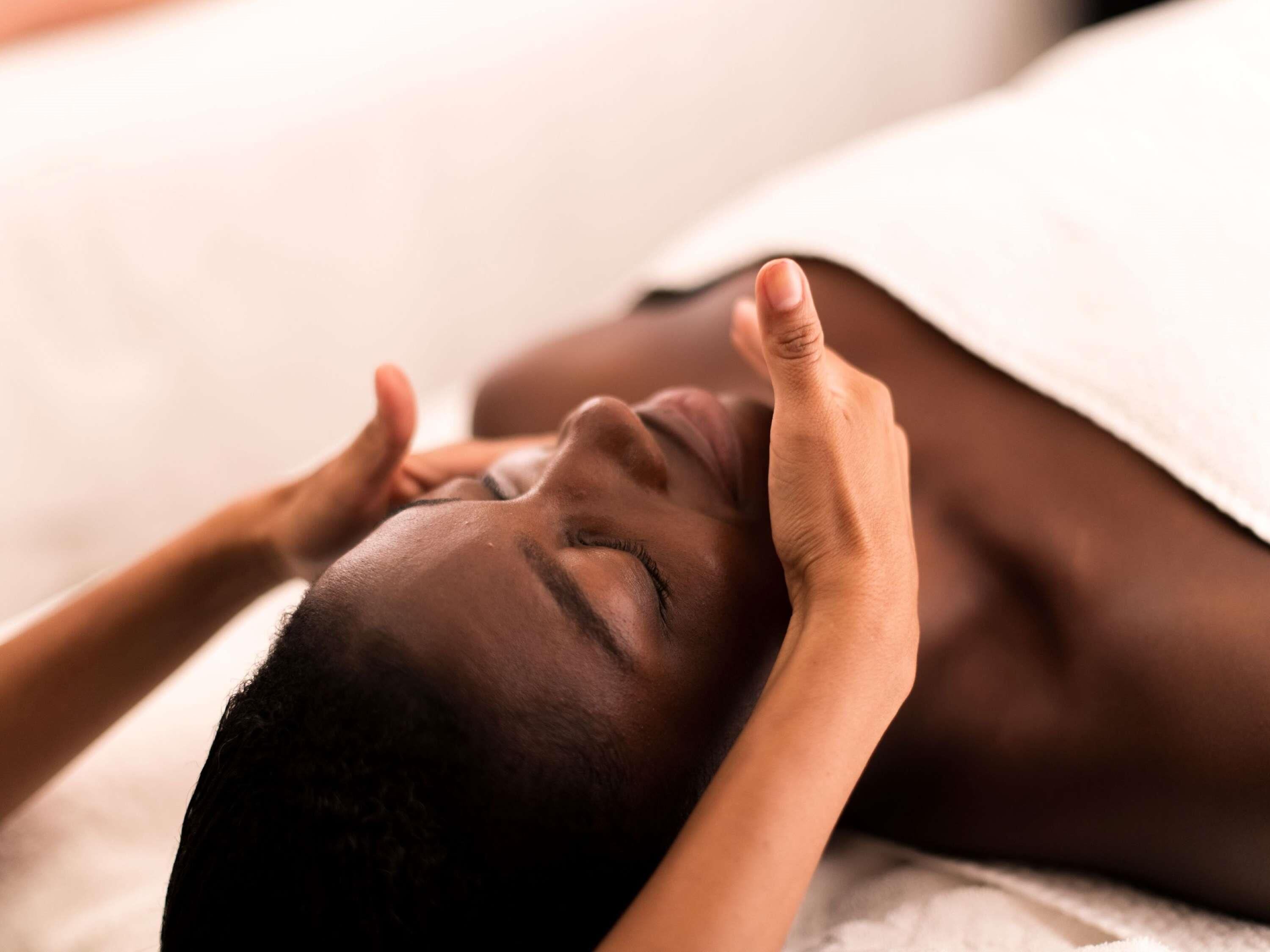 Une personne allongée, la tête reposant sur un oreiller.