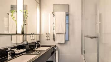 Un baño moderno con dos lavamanos, un espejo grande y una cabina de ducha de vidrio.