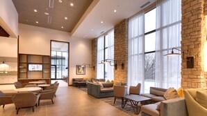 A spacious lobby with a mix of seating options, large windows, and a stone accent wall. - Hyatt Place Park City (Park City)