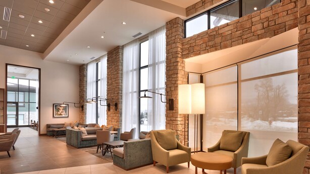 A spacious lobby with a high ceiling, large windows, and a mix of seating areas including sofas and armchairs. - Hyatt Place Park City (Park City)