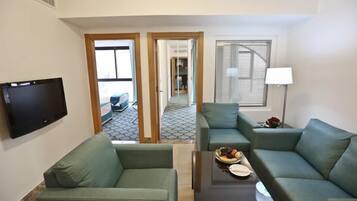 Suite, 2 chambres | Salle de séjour | Télévision LED